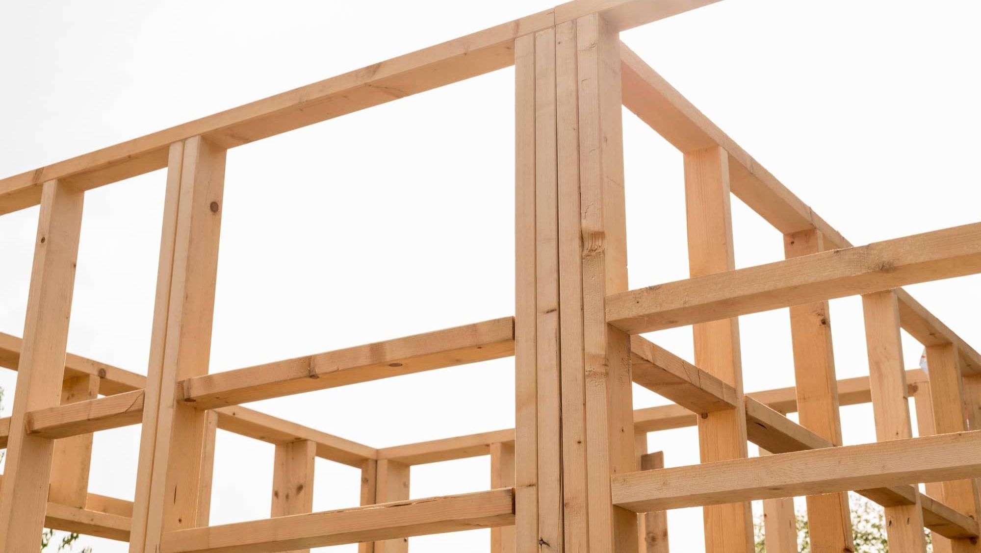 Reisverk i tre under oppføring, viser konstruksjon av nytt bygg i tidlig fase.